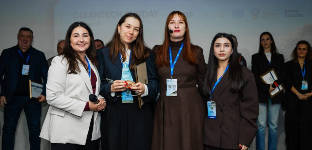 A winning startup representative receiving their award on stage during the Cleantech Sunday event.